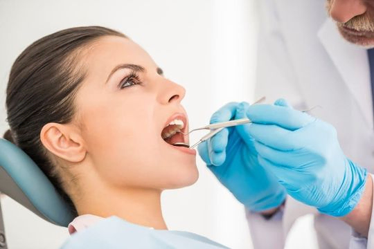 dentista revisando la boca de una paciente